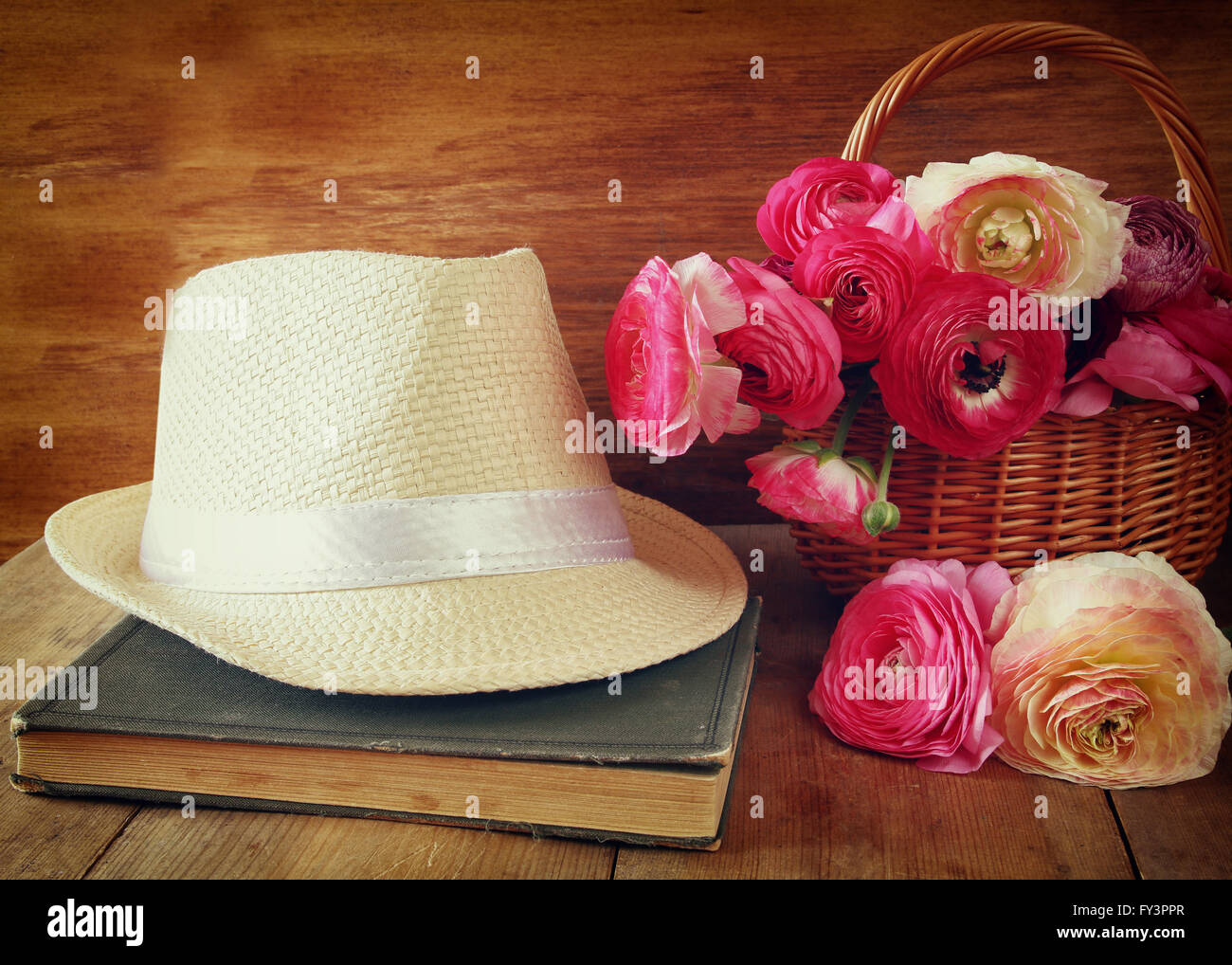 Fedora-Hut neben altes Buch und Blumen auf Holztisch. Jahrgang gefiltert und getönten Stockfoto