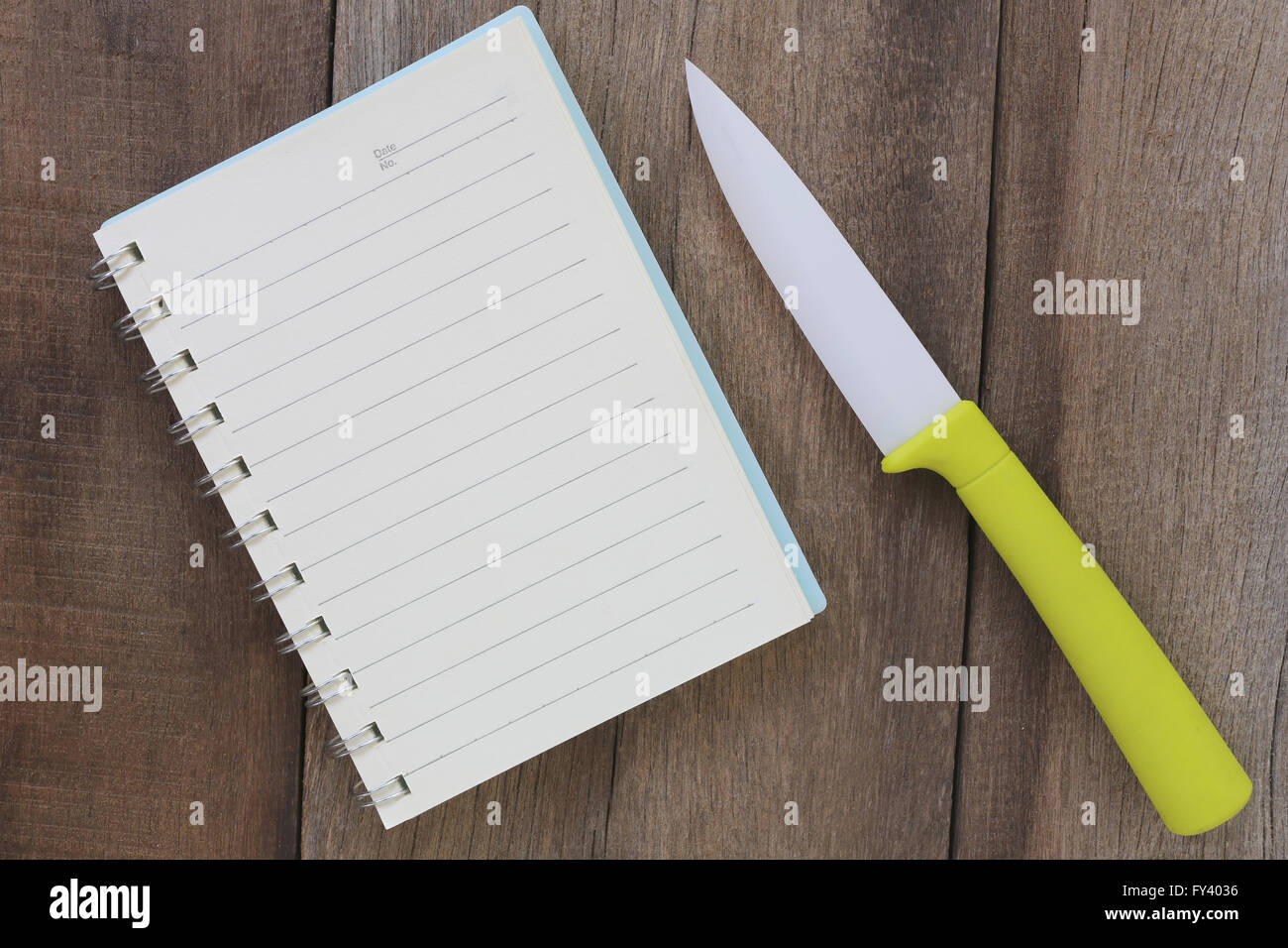 Notebook und Acryl Messer platziert auf dem alten Holzboden, rostet nicht Gestaltungskonzept für Messer. Stockfoto