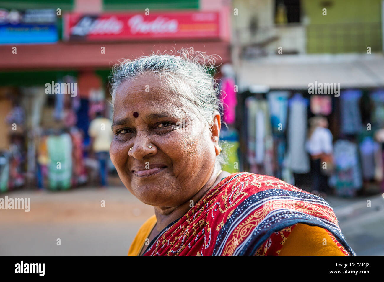 Inderin, die entlang der Straße in Kuilapalayam schaut die Kamera und das Lächeln Stockfoto