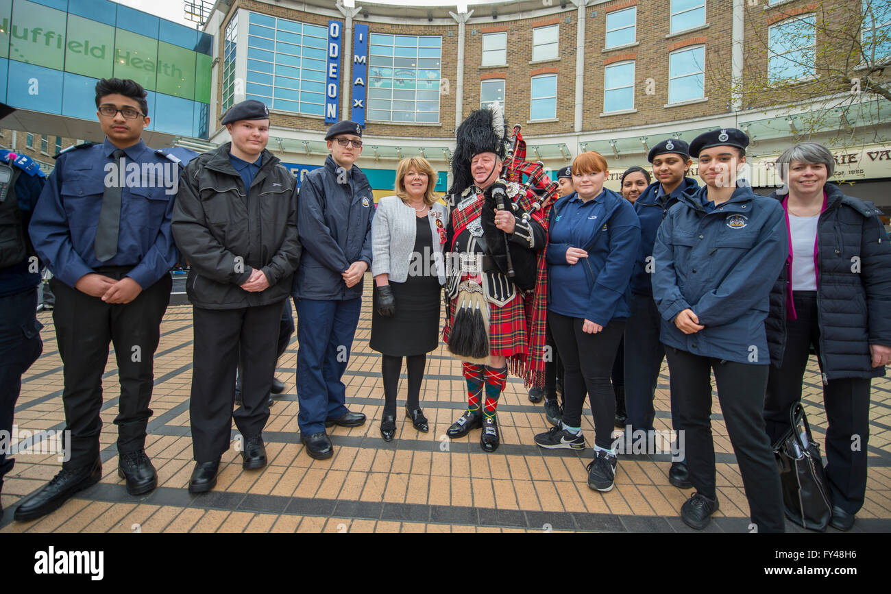 Wimbledon, London, UK. 21. April 2016. Deputy Lieutenant von Merton Frau Clare Whelan OBE DL mit Pipe Major Tony Kelly und Metropolitan Polizeikadetten an der Piazza in Wimbledon Stadt Zentrum für das Leuchtfeuer Beleuchtung Zeremonie im Rahmen der internationalen Leuchtturm Beleuchtung Veranstaltung zum 90. Geburtstag der Queen zu feiern. Wimbledon ist Standort eines der vier Baken quer durch London beleuchtet werden. Bildnachweis: Malcolm Park Leitartikel/Alamy Live-Nachrichten. Stockfoto