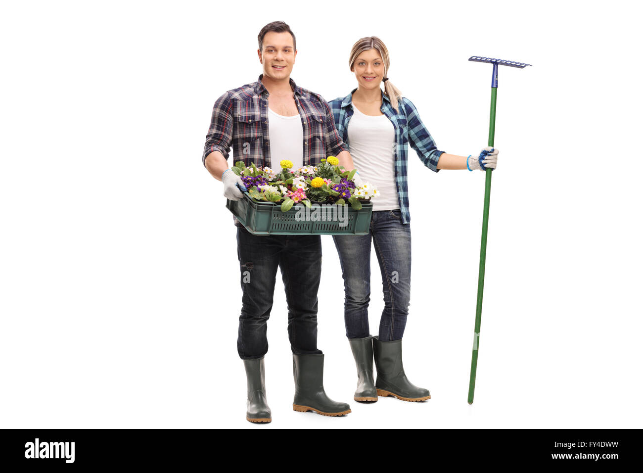 Junger Mann und eine Frau posiert mit Gartengeräten und Blumen isoliert auf weißem Hintergrund Stockfoto