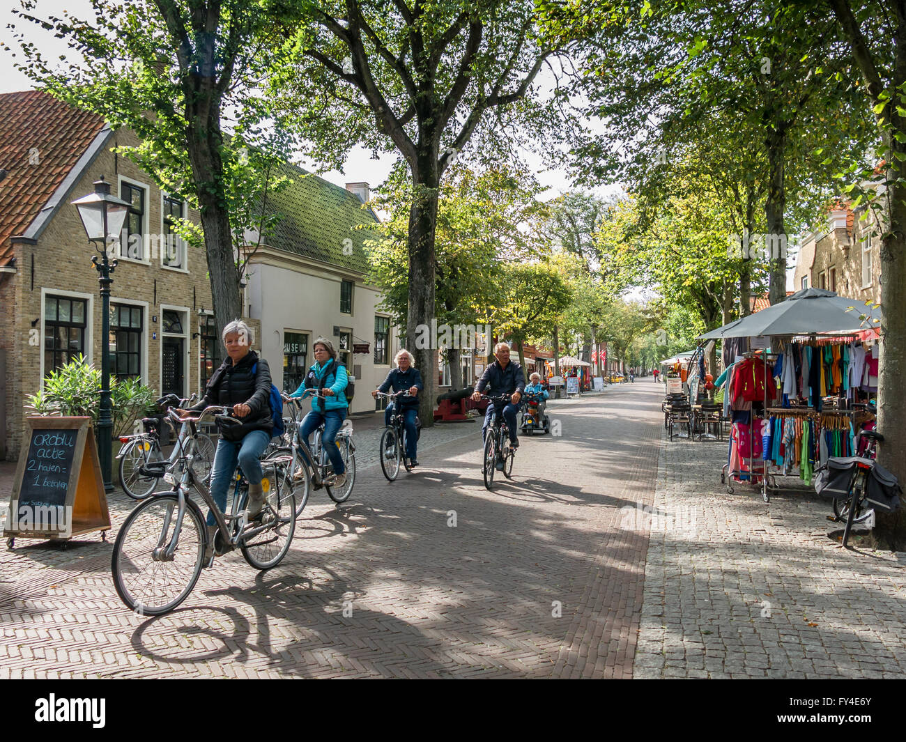 Touristen, die sightseeing auf Fahrräder in der Main Street von Ost-Vlieland auf Vlieland Insel im Wattenmeer, Friesland, Niederlande Stockfoto