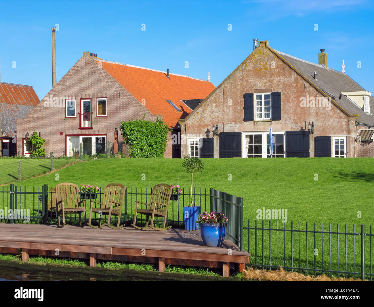 Bauernhäuser mit Liegewiese am Deich in Eemdijk in der Provinz Utrecht, Niederlande Stockfoto