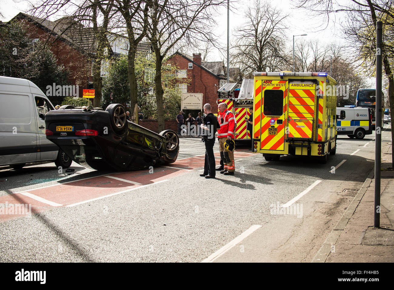 Schwarzer Audi Auto kopfüber, weiß, Transit, ArbeitsPartei Banner, Krankenwagen, Polizisten, Feuerwehrleute, Feuerwehrauto, Polizei-Transporter, bus Stockfoto