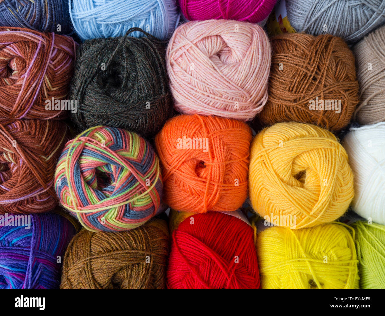 Blick von oben auf eine rechteckige Anordnung von vielen leuchtend bunte Kugeln aus Wolle. Stockfoto