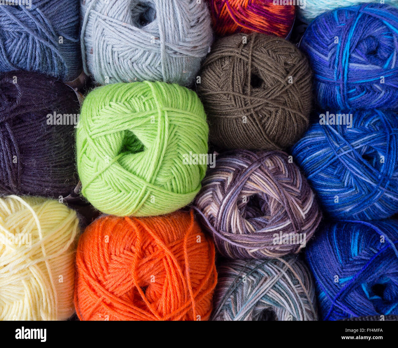 Blick von oben auf eine rechteckige Anordnung von vielen leuchtend bunte Kugeln aus Wolle. Stockfoto