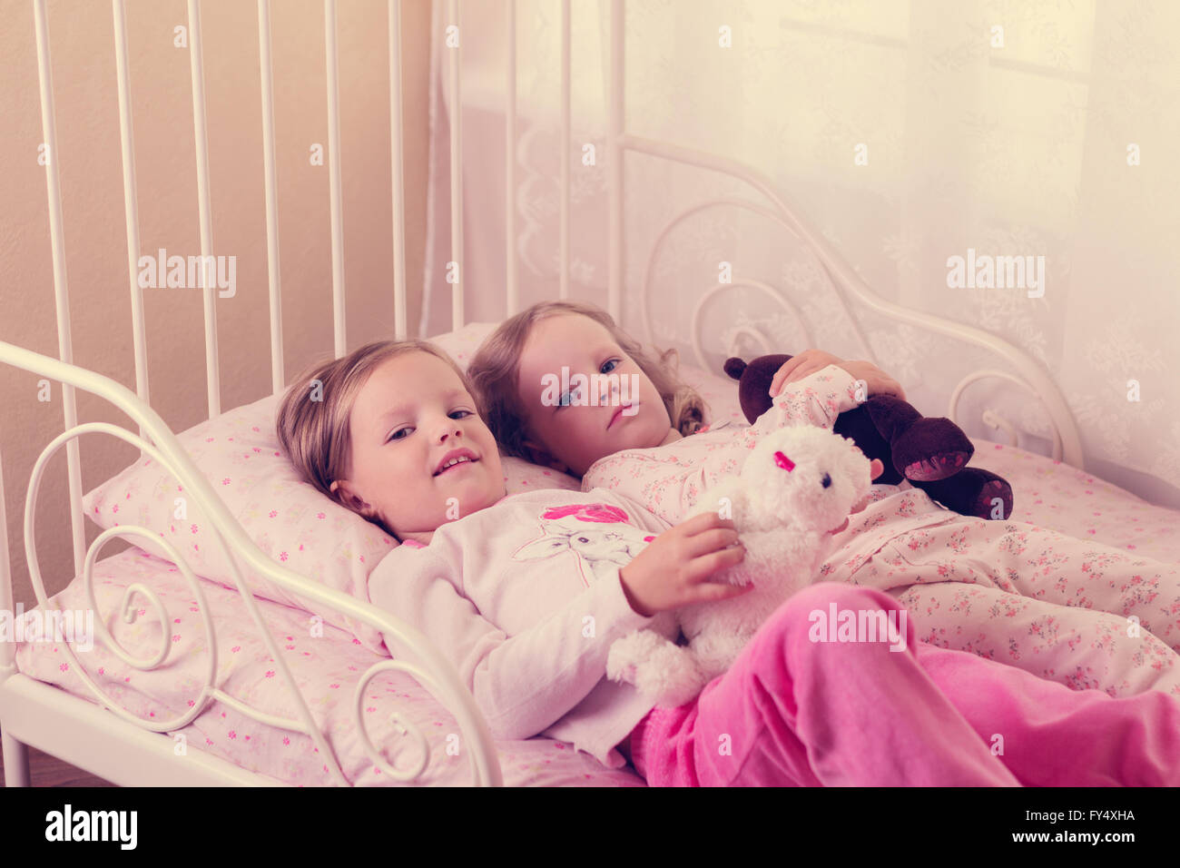 Kleine süße Mädchen (Schwestern) spielen im Bett. Selektiven Fokus. Stockfoto