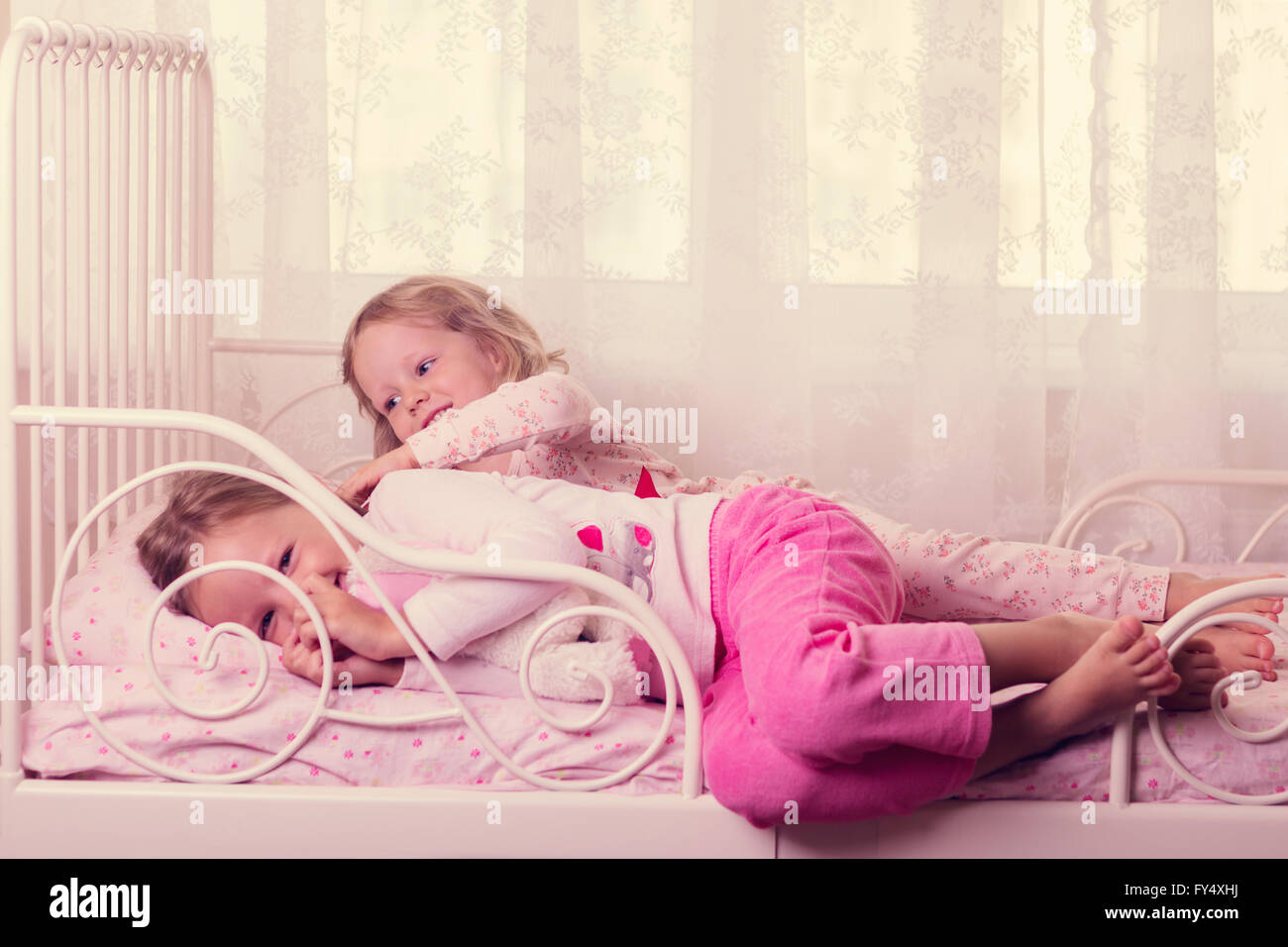 Kleine süße Mädchen (Schwestern) spielen im Bett. Selektiven Fokus. Stockfoto