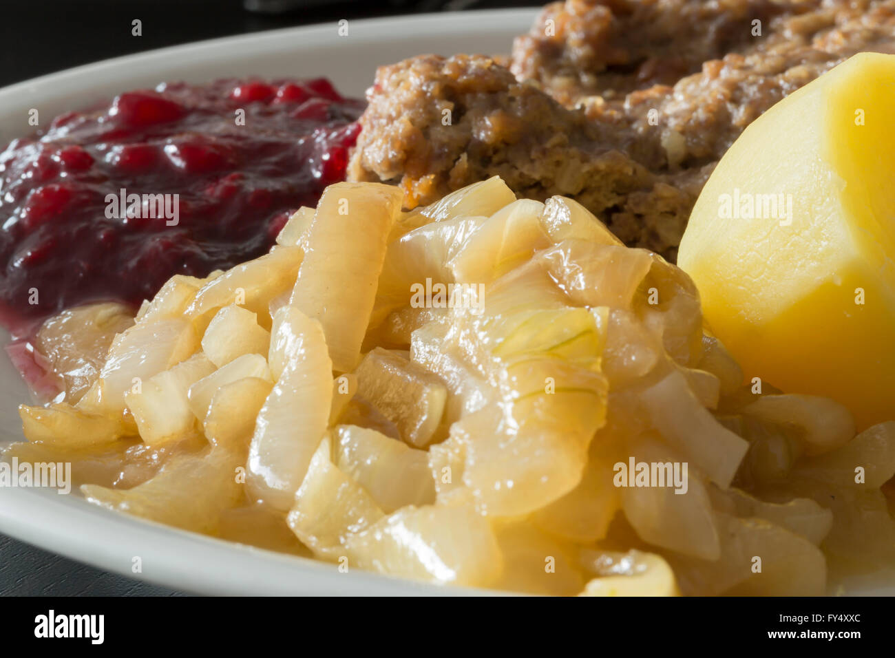 Hackbraten mit Kartoffeln, Zwiebeln karamelisiert und Preiselbeerkonfitüre Stockfoto