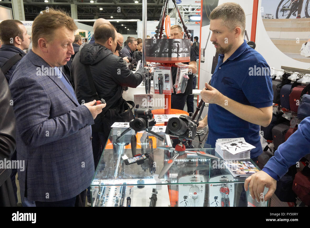 Moskau Crocus Expo, Moskau, Russland - 15. April 2016: Berater zeigt Manfrotto Mini-Stativ für einen Besucher auf Saskia 2016 Stockfoto
