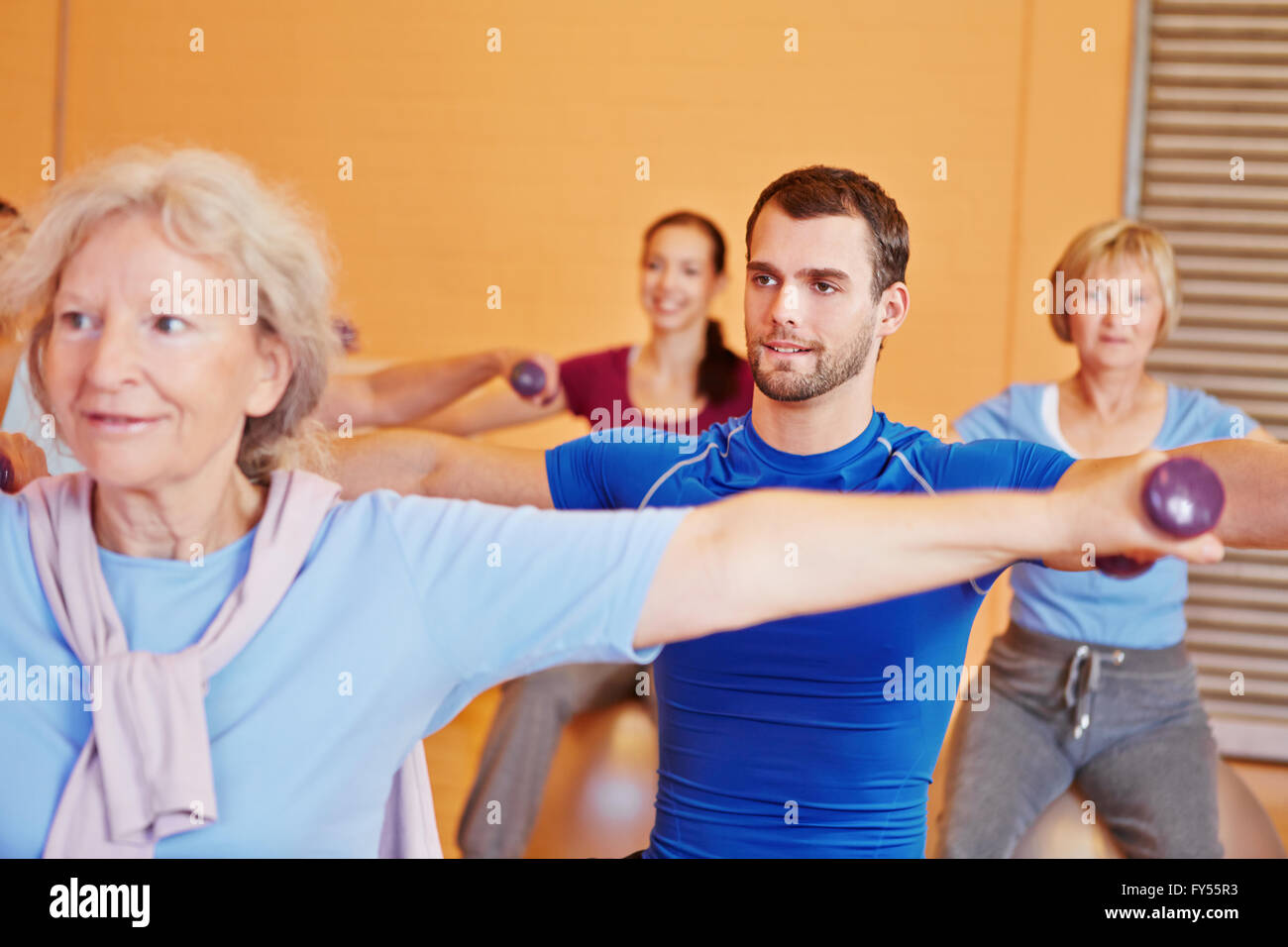 Junger Mann Aufhebung Hanteln im Rücken training Klasse im Fitness-Studio Stockfoto