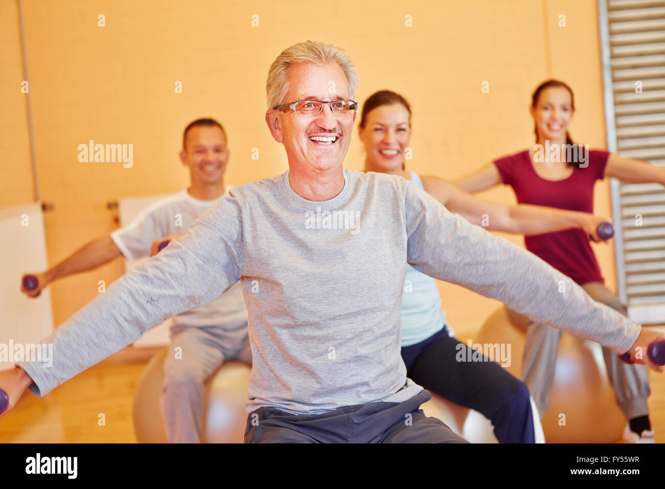 Lächelnde Senior im Rücken training Klasse mit Hanteln im Fitness-center Stockfoto