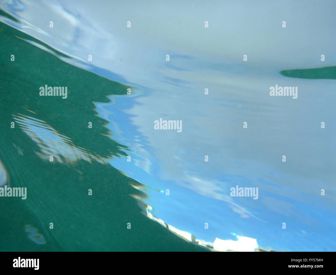 Blick durch Meerwasser am blauen Himmel mit Wasser plätschert und Luftblasen unter Wasser aus. Stockfoto