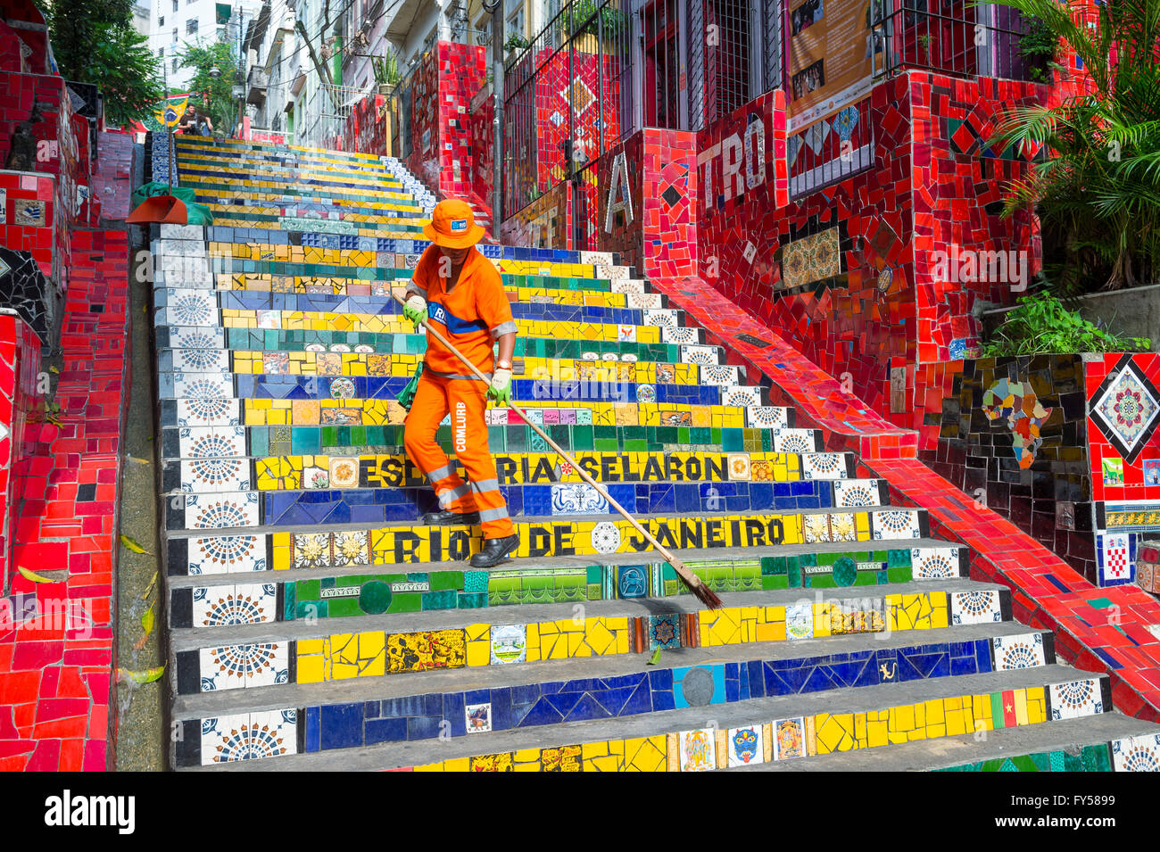 RIO DE JANEIRO - 29. März 2016: Ein städtischer COMLURB Arbeiter fegt die bunte Mosaik gefliesten Treppe des Escadaria Selarón. Stockfoto