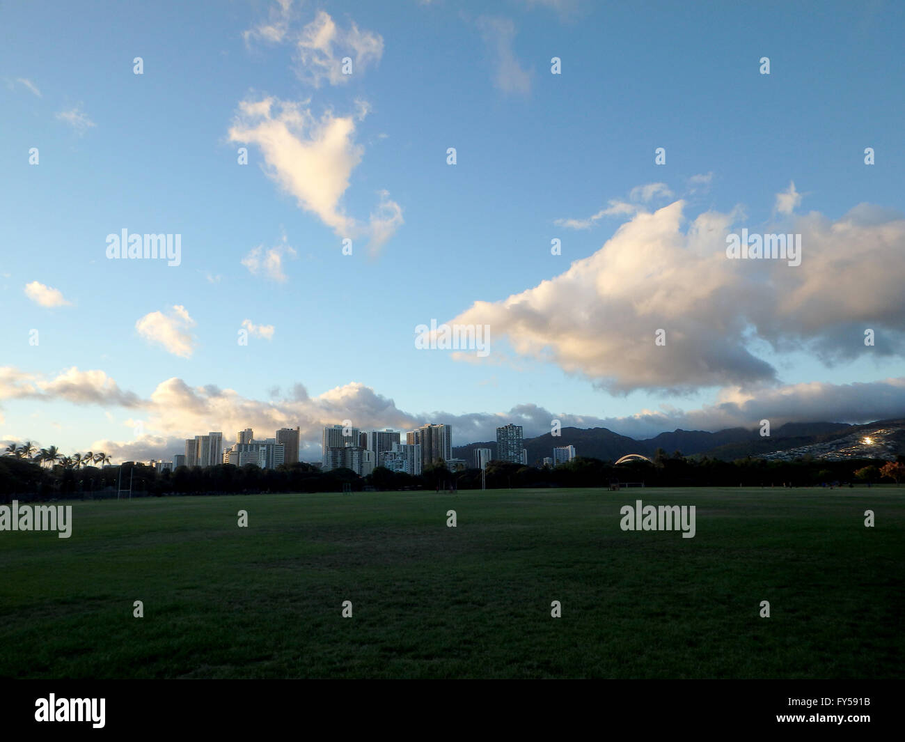 Kapiolani Park in der Abenddämmerung mit Hotels von Waikiki in der Ferne auf Oahu, Hawaii. Stockfoto