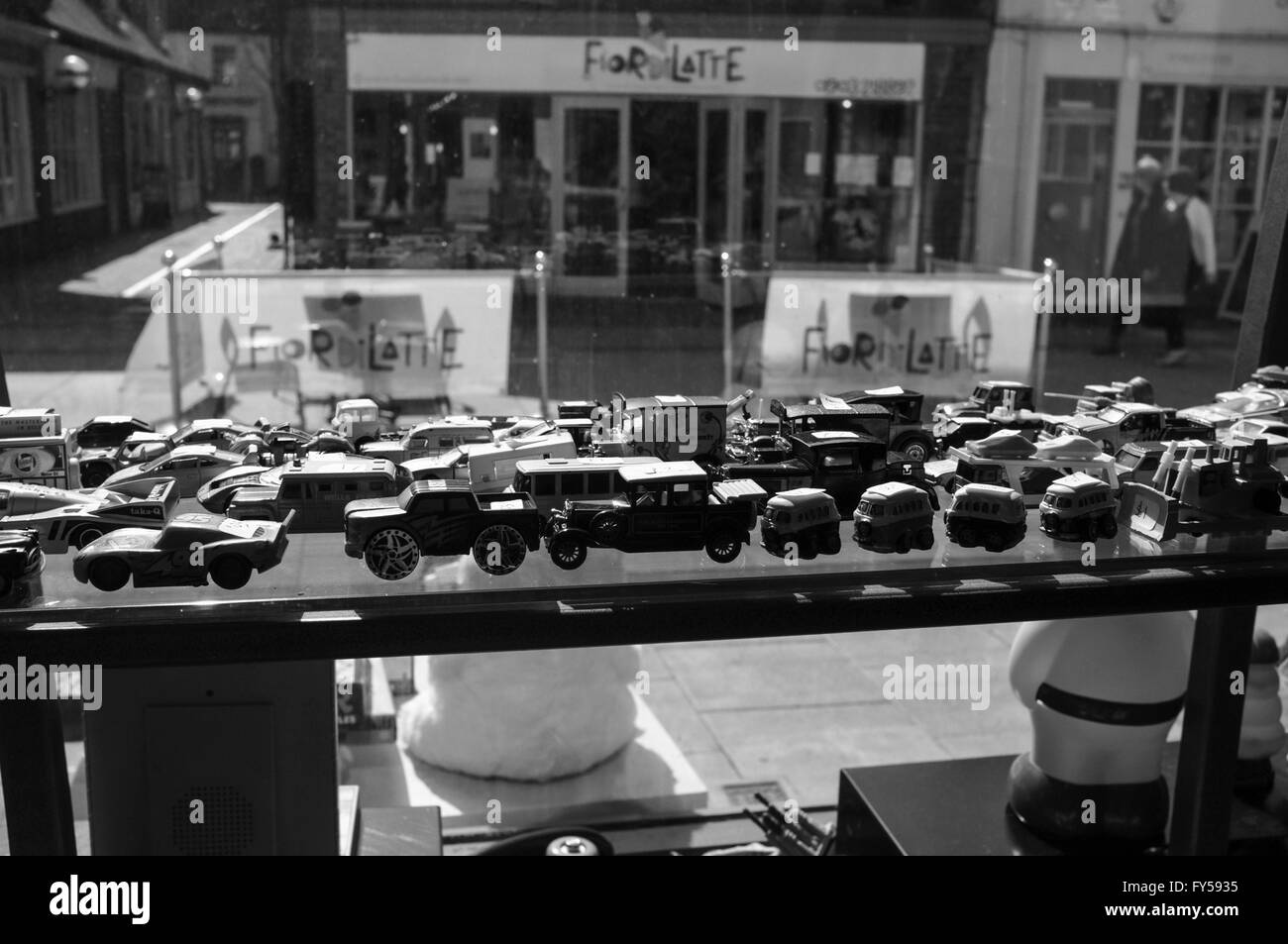 Eine schwarz-weiß Bild von alten Spielzeugautos im Fenster shop Stockfoto