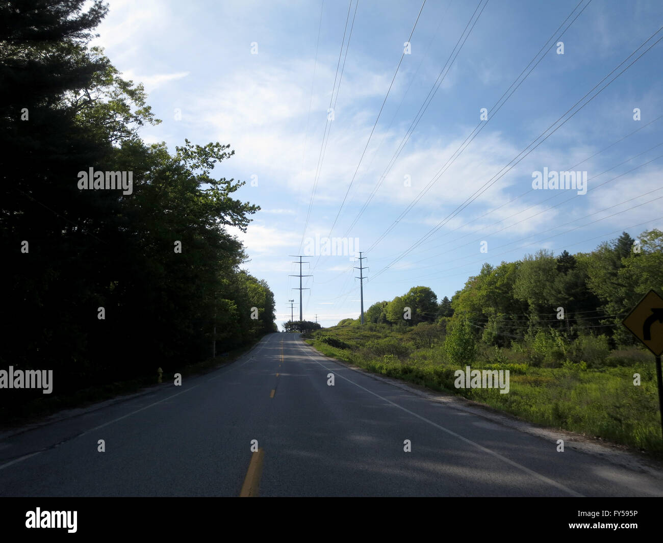 Empty Road with trees casting a shadow on road in Maine Stockfoto