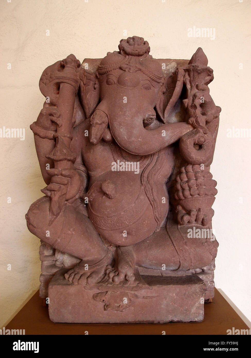 Sitzender Ganesha, hergestellt in Indien aus Sandstein im 9. Jahrhundert in Honolulu Art Musuem.  Unter die Objekten hält Ganesha ist seine ow Stockfoto