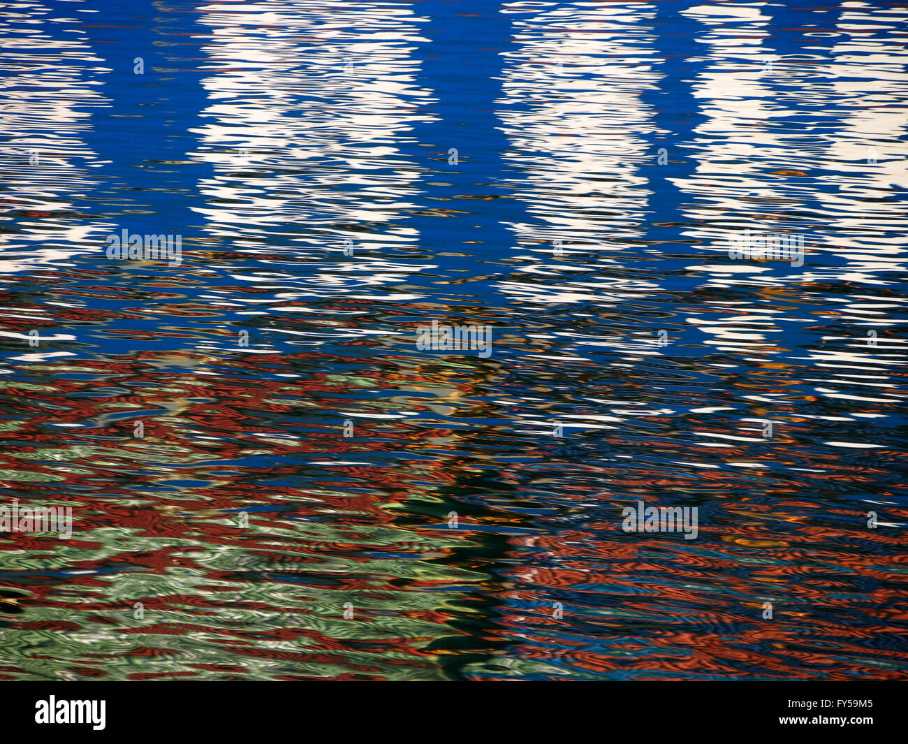 Rot-blau-weißen Farbenmuster schimmert und spiegelt sich in den Wellen des Wassers eine psychedelische Muster. Stockfoto
