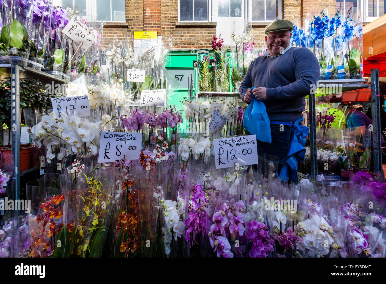 Ein Mann verkauft Orchideen an Columbia Road Flower Market, Tower Hamlets, London, England Stockfoto