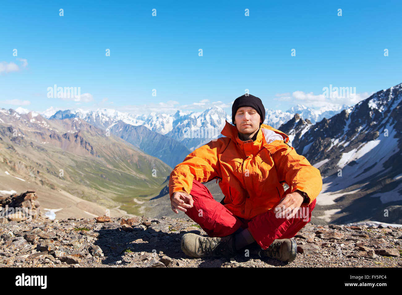 Meditierende Bergsteiger in Bergen Stockfoto