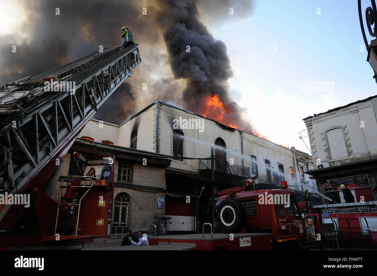 Damaskus, Syrien. 23. April 2016. Eine riesige Wolke aus Rauch und Feuer Aufstieg über den alten Markt von Al-Assroniyah-Markt, der sich zwischen der historischen Zitadelle und die berühmten Souk Al-Hamidiyah in der alten ummauerten Stadt Damaskus, Hauptstadt von Syrien, am 23. April 2016. Ein großes Feuer brach aus in Al-Assroniyah frühen Samstagmorgen, verursacht große Sachschäden. Offizielle wurde berichtet, dass das Feuer durch einen Kurzschluss verursacht wurde. Bildnachweis: Ammar/Xinhua/Alamy Live-Nachrichten Stockfoto