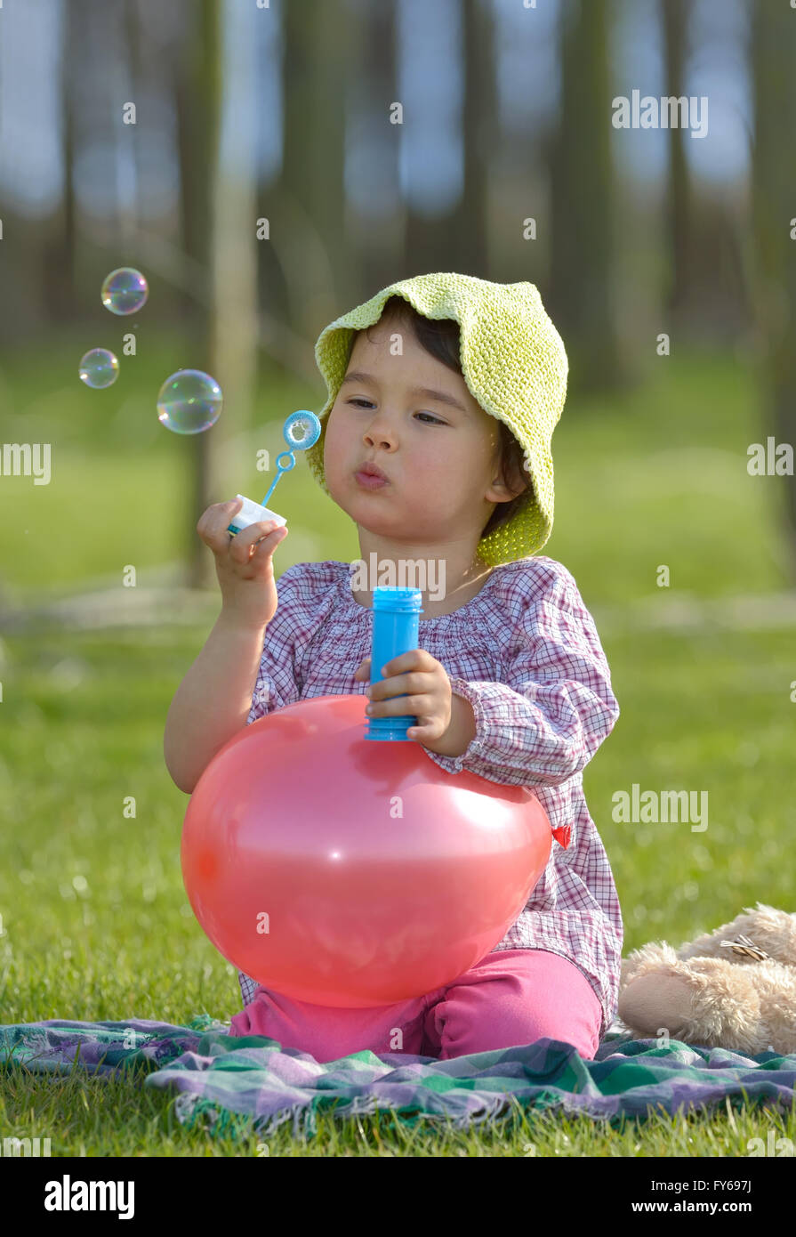 kleines Mädchen mit Seifenblasen Spaß im freien Stockfoto