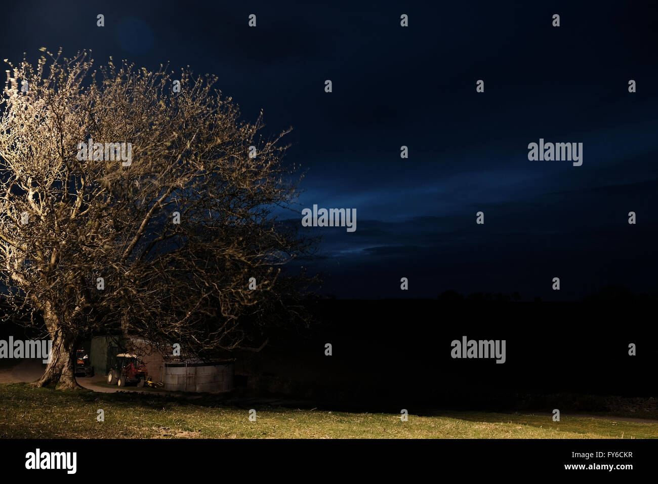 Nachtszene auf ländlichen Bauernhof mit Baum und Bauernhof Zugfahrzeuge UK Stockfoto