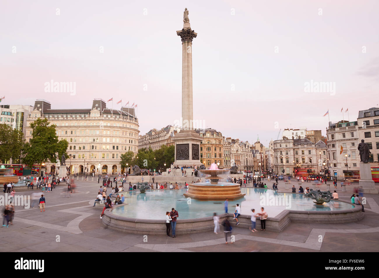 Trafalgar Square mit Menschen und Touristen in der Abenddämmerung in London Stockfoto