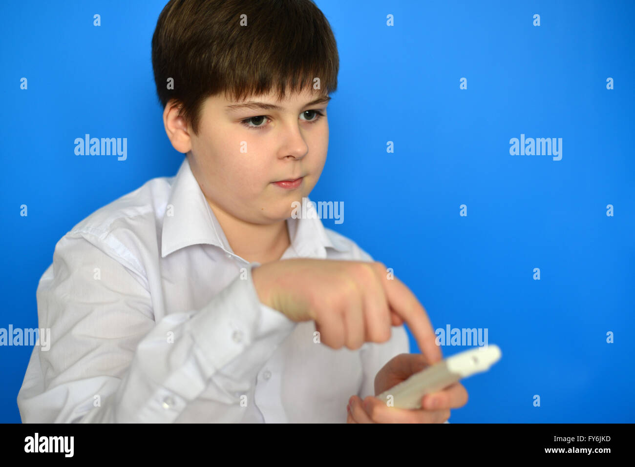 Junge Teenager mit TV-Fernbedienung auf blauem Hintergrund Stockfoto