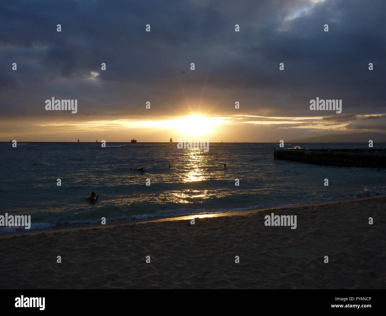 Dramatischen Sonnenuntergang am Strand von Kaimana an bewölkten Tag auf Oahu, Hawaii. Stockfoto
