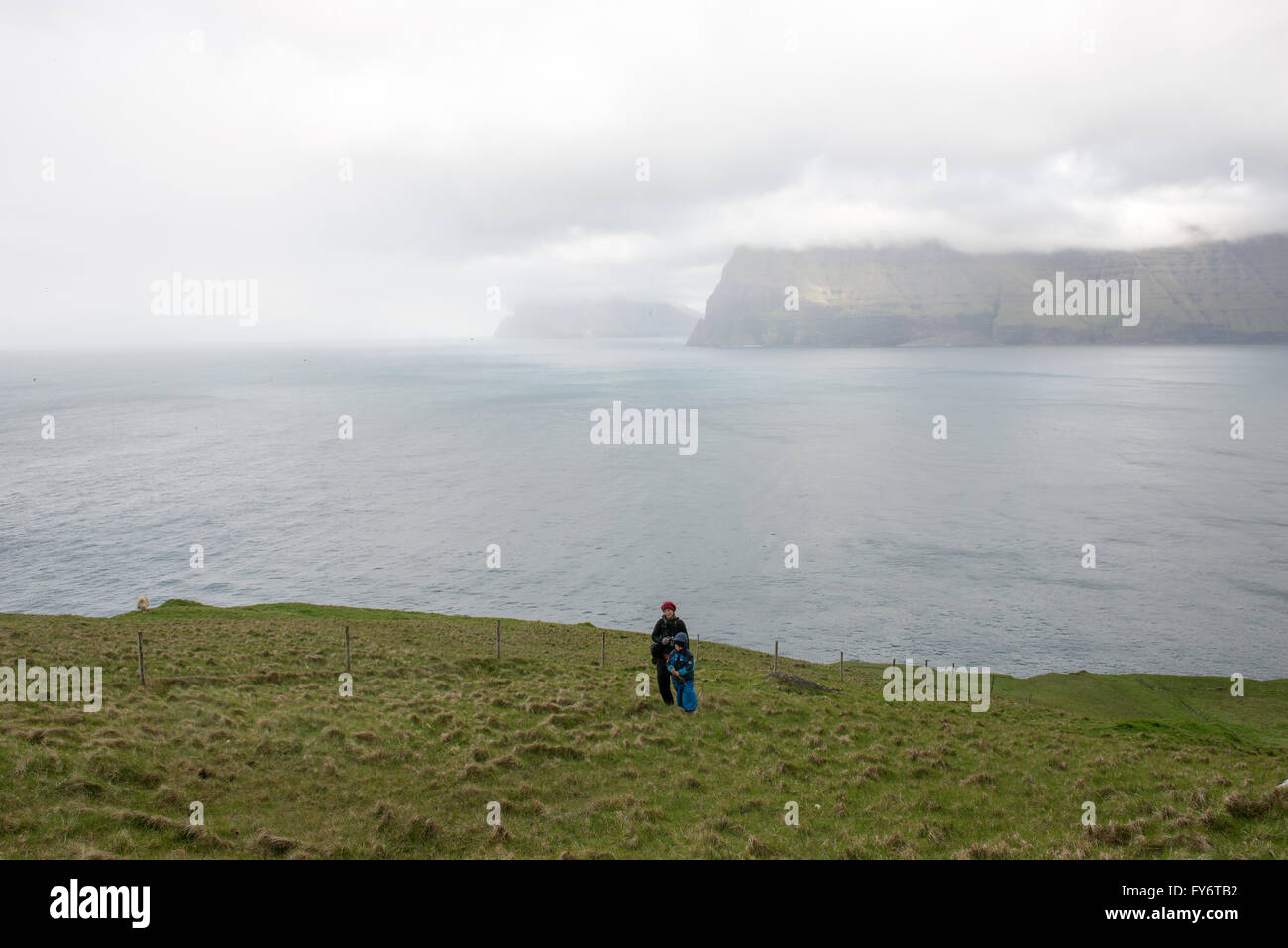 Menschen wandern auf den Färöern auf der Insel Kalsoy mit vidoy im Hintergrund Stockfoto