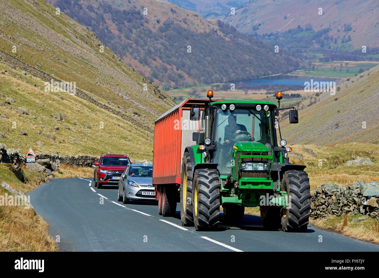 Traktor hält Verkehr auf Kirkstone Pass (A592), Lake District National Park, Cumbria, England Großbritannien Stockfoto