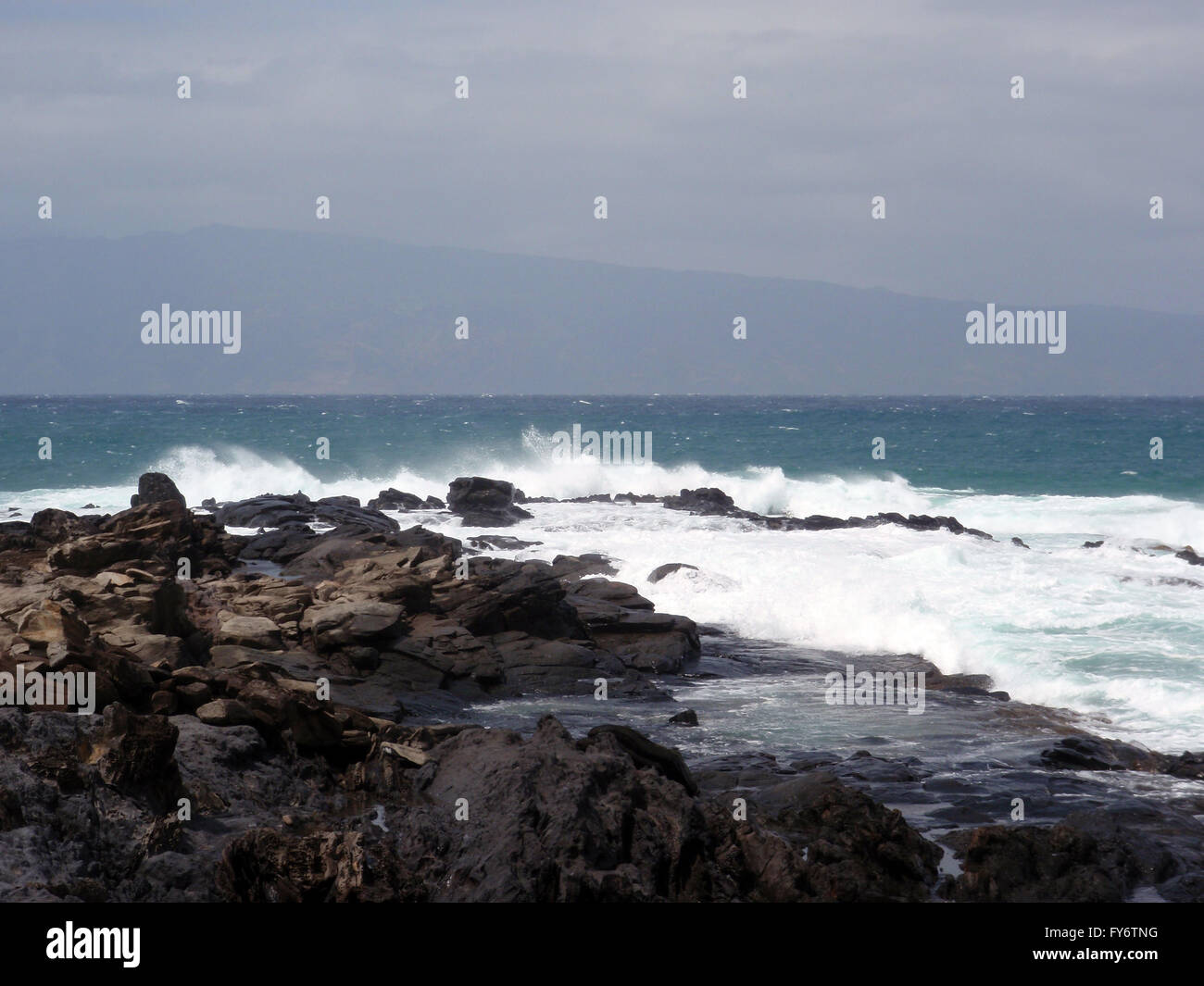 Nebel aus Wellen Sprays in der Luft, wie es gegen Lavafelsen auf Maui, Hawaii stürzt Stockfoto