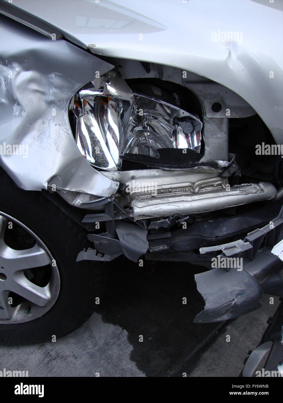 Durch Unfall vorderen Scheinwerfer eines Autos auf einer Garage geparkt zerkleinert, Stockfoto