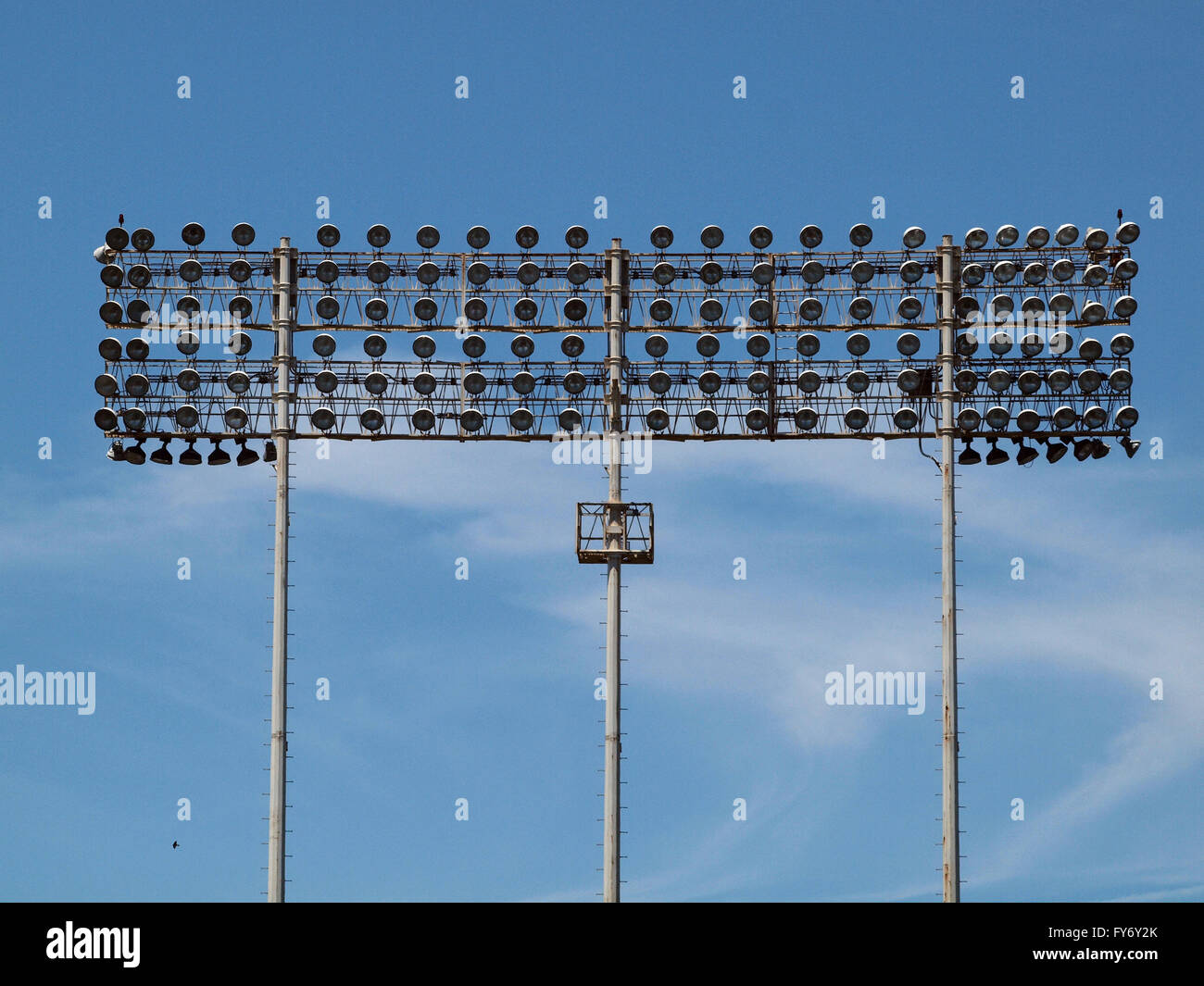 Stadion-Art Lichter am Oakland Coliseum freut sich blauer Himmel mit swirly Wolken und ein kleiner Vogel fliegt in der b Stockfoto