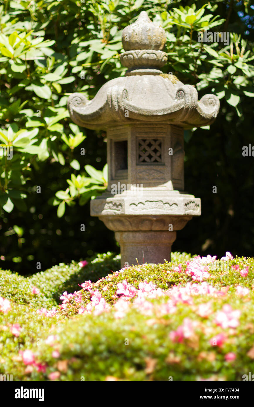 Eine kleine graue Garten Pagode in einem japanischen Garten auf rosa Rhododendron-Büsche. Stockfoto