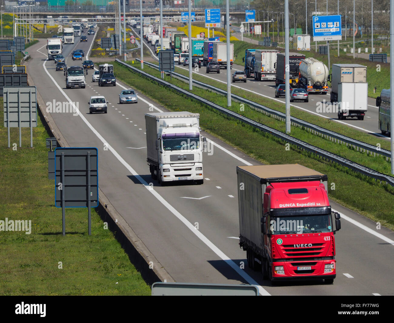 Viele Lkw-Verkehr auf der E19 in der Nähe der belgisch-niederländischen Grenze bei Hazeldonk (mit Blick auf die Niederlande) Stockfoto