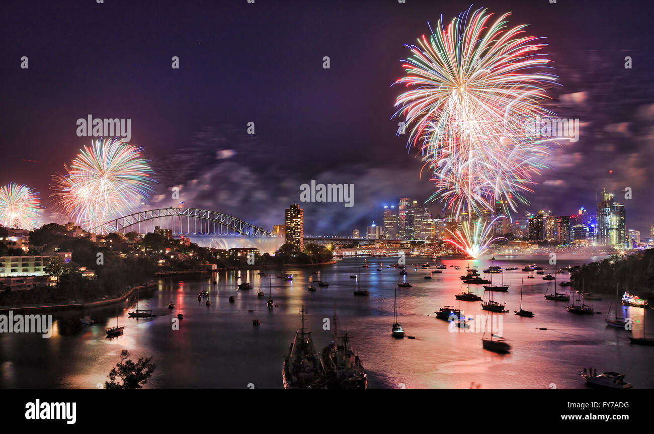 Sydney Neujahr Silvester Feuerwerk über dem Hafen mit Brücke und Stadt CBD Gebäuden reflektiert bunten Feuerkugeln in unscharfen Wasser. Stockfoto