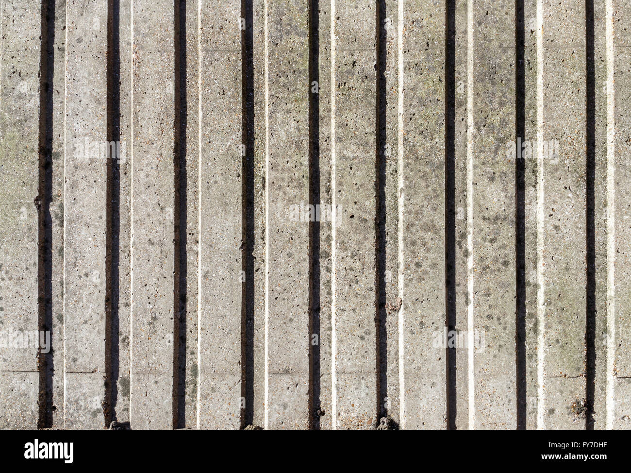 Verwittert und gefärbten graue Betonwand mit vertikalen Muster für den Hintergrund Stockfoto