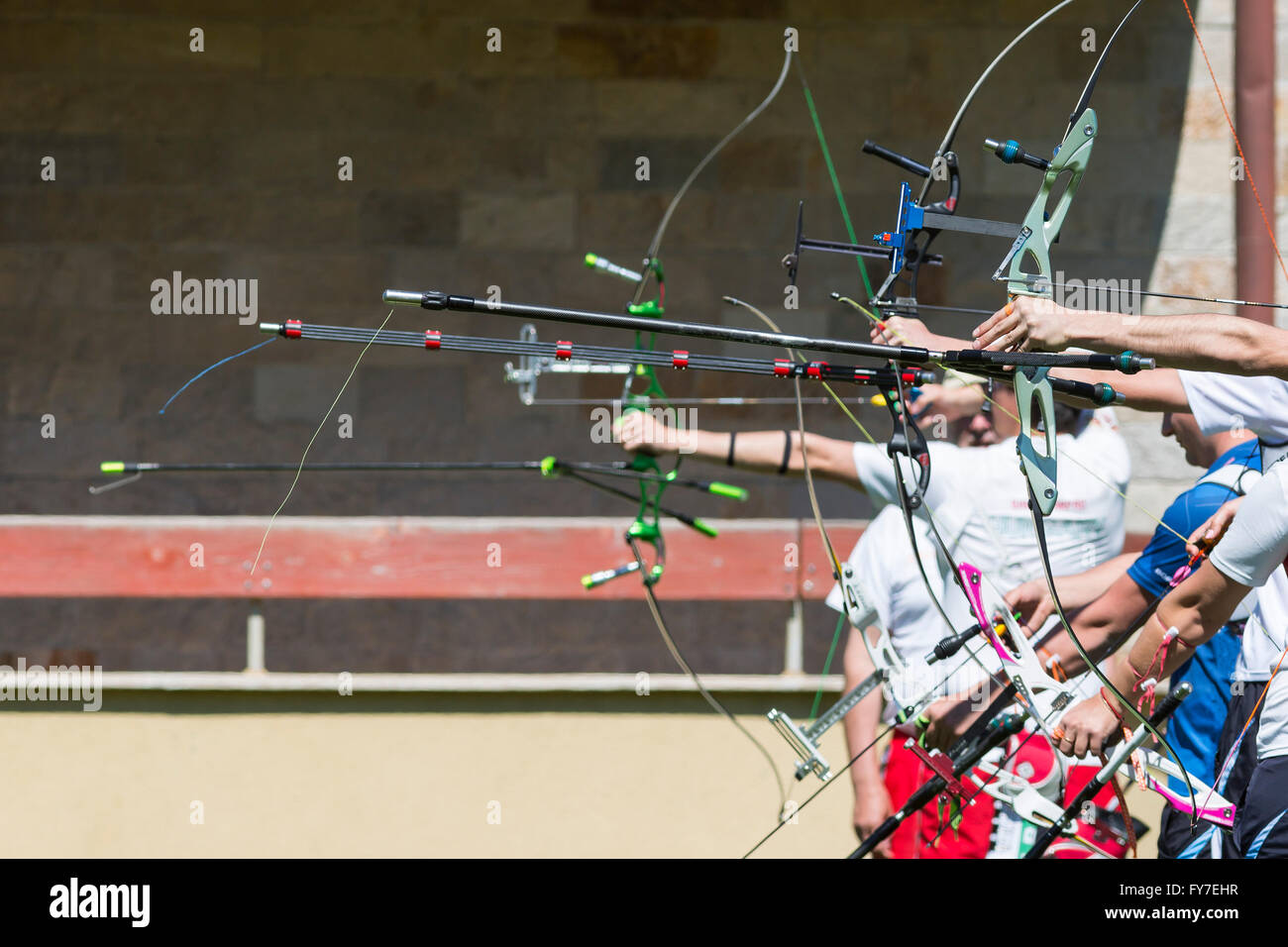 Menschen sind während eines Wettbewerbs Bogenschießen mit Recurve Bogen schießen. Hände und Bögen nur. Stockfoto