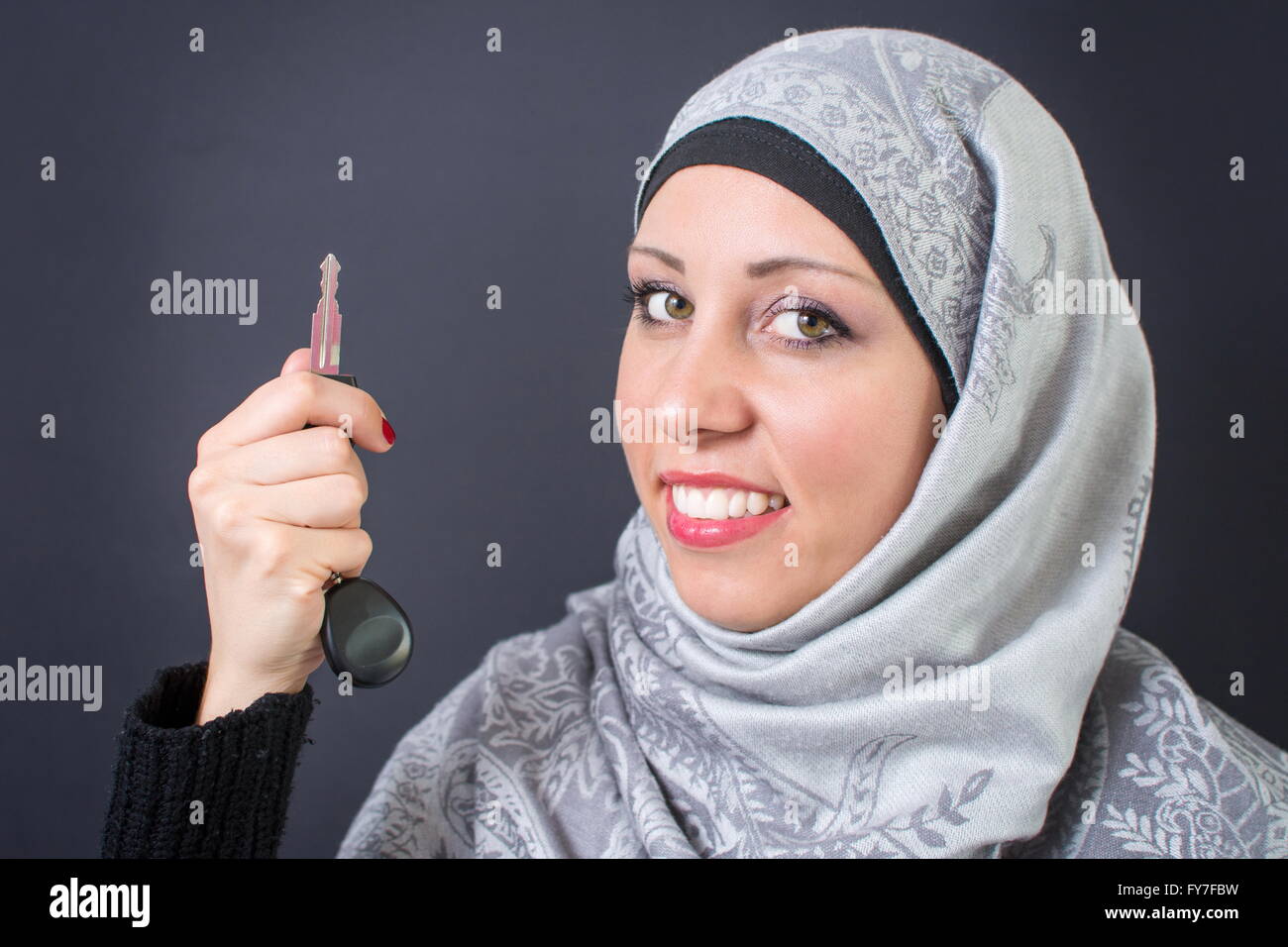 Wunderschöne muslimische Frau hält einen Autoschlüssel Stockfoto