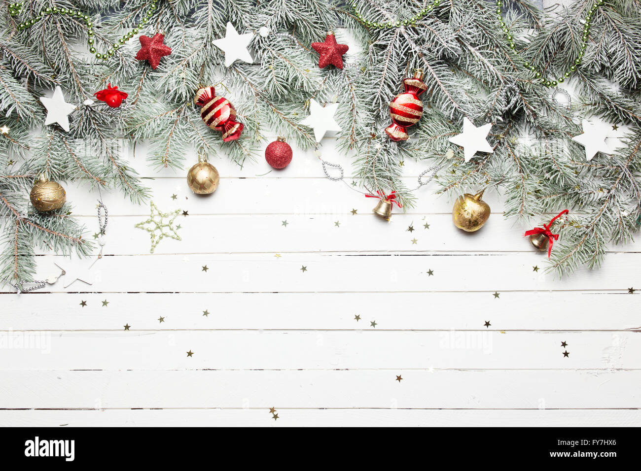 Weihnachten oder Silvester-Dekoration-Hintergrund: Tanne Äste, bunte Glaskugeln und glitzernden Sternen auf weißem Holz Hintergrund, Ansicht von oben kopieren Raum Stockfoto