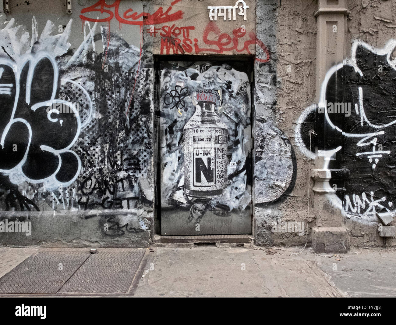 Eine Tür an der West 24th Street Sixth Avenue in Manhattan mit Graffiti und Street Art. New York City Stockfoto