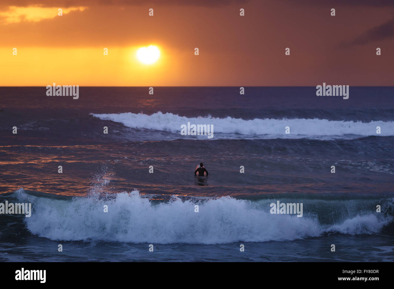 Einsamer Surfer vor der Sonne wartet eine große Welle Furadouro Strand, Ovar, Portugal. Stockfoto