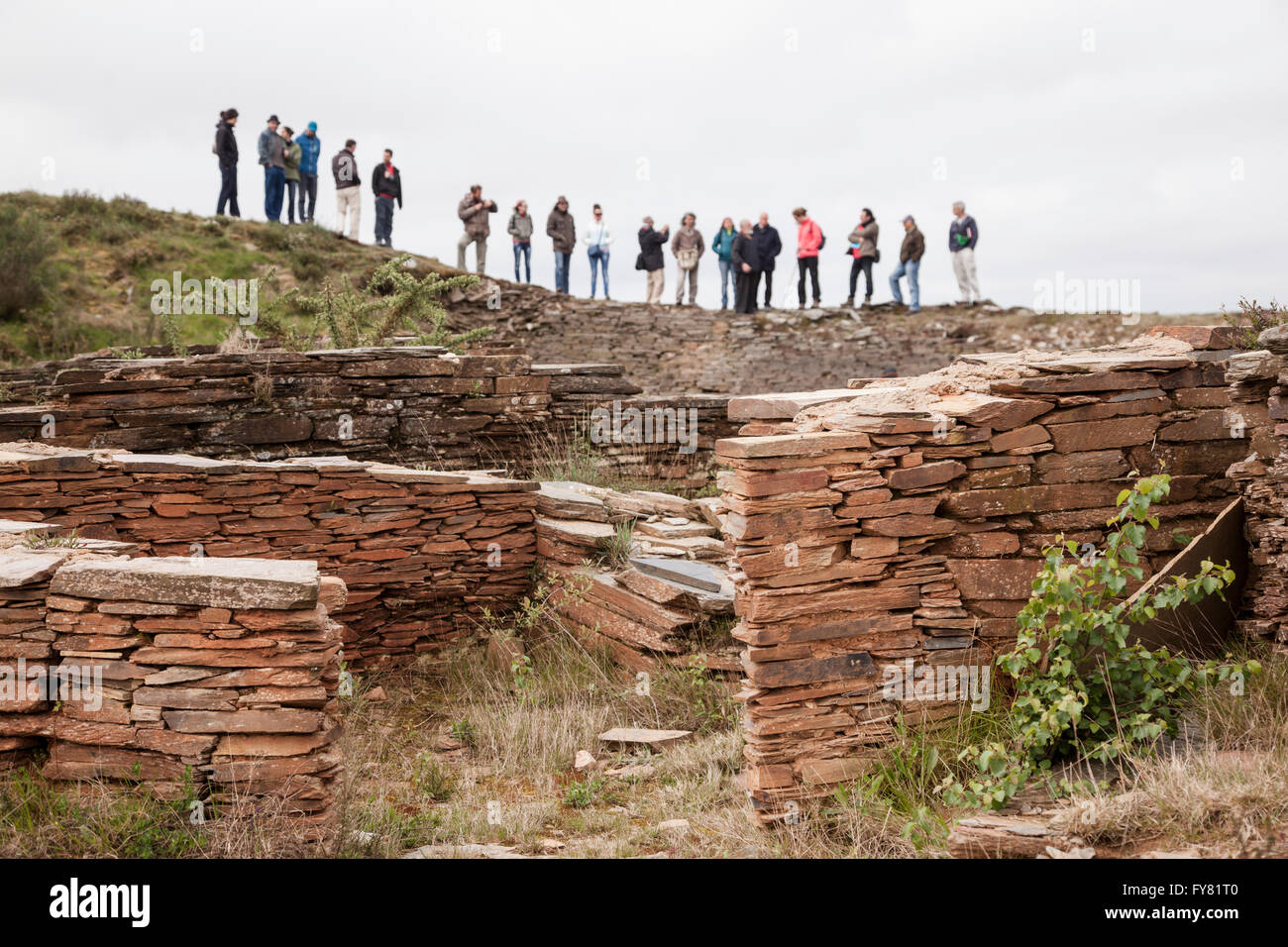 Eine Gruppe von Menschen, die Besichtigung der Ruinen einer prähistorischen menschlichen Siedlung (Castro) in Galizien, nördlich von Spanien Stockfoto