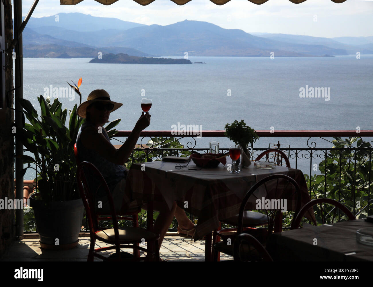 Silhouette von Frau mit Glas Wein trinken von Wein in einem Restaurant in der Ägäis Resort von Molyvos auf der Insel Lesbos in Griechenland Stockfoto