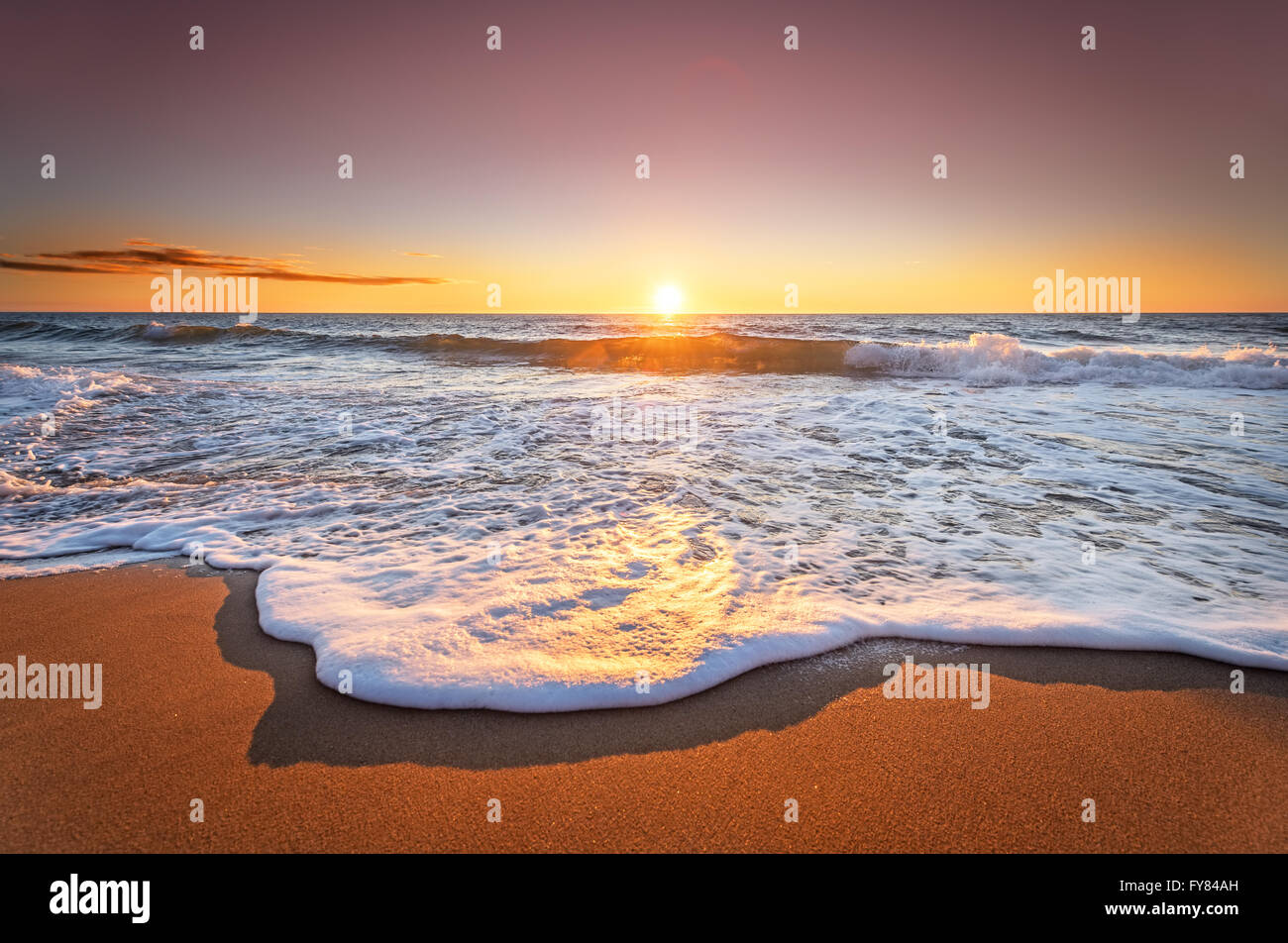 Bunte Meer Strand Sonnenaufgang mit tief blauen Himmel und Sonne Strahlen. Stockfoto