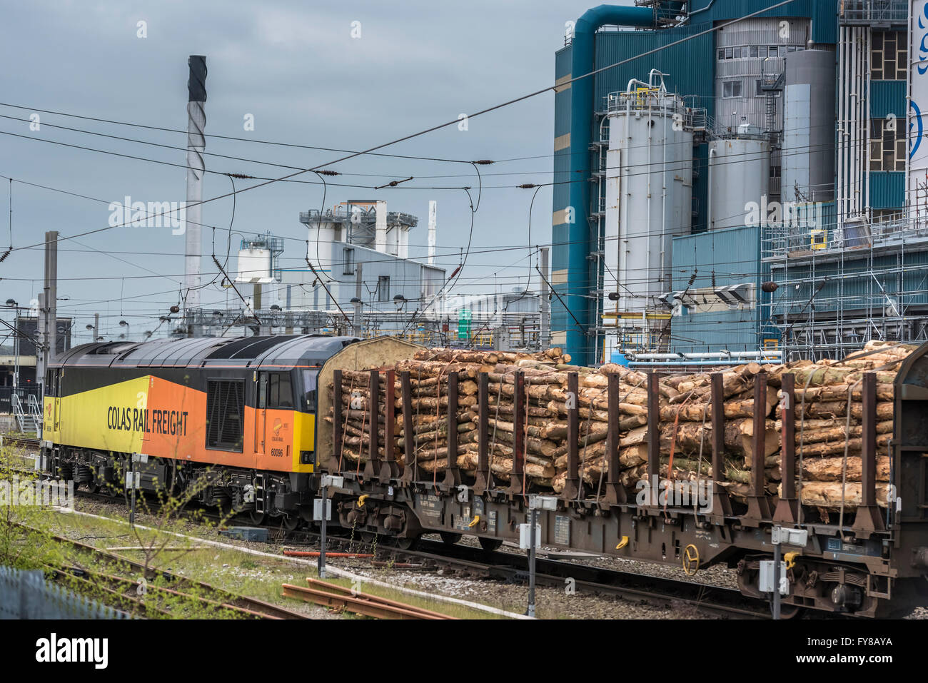 Eine Cloas Railfreight Diesellok schleppt einen Zug des Holzes durch Bahnhof Warrington Bank Quay. Stockfoto