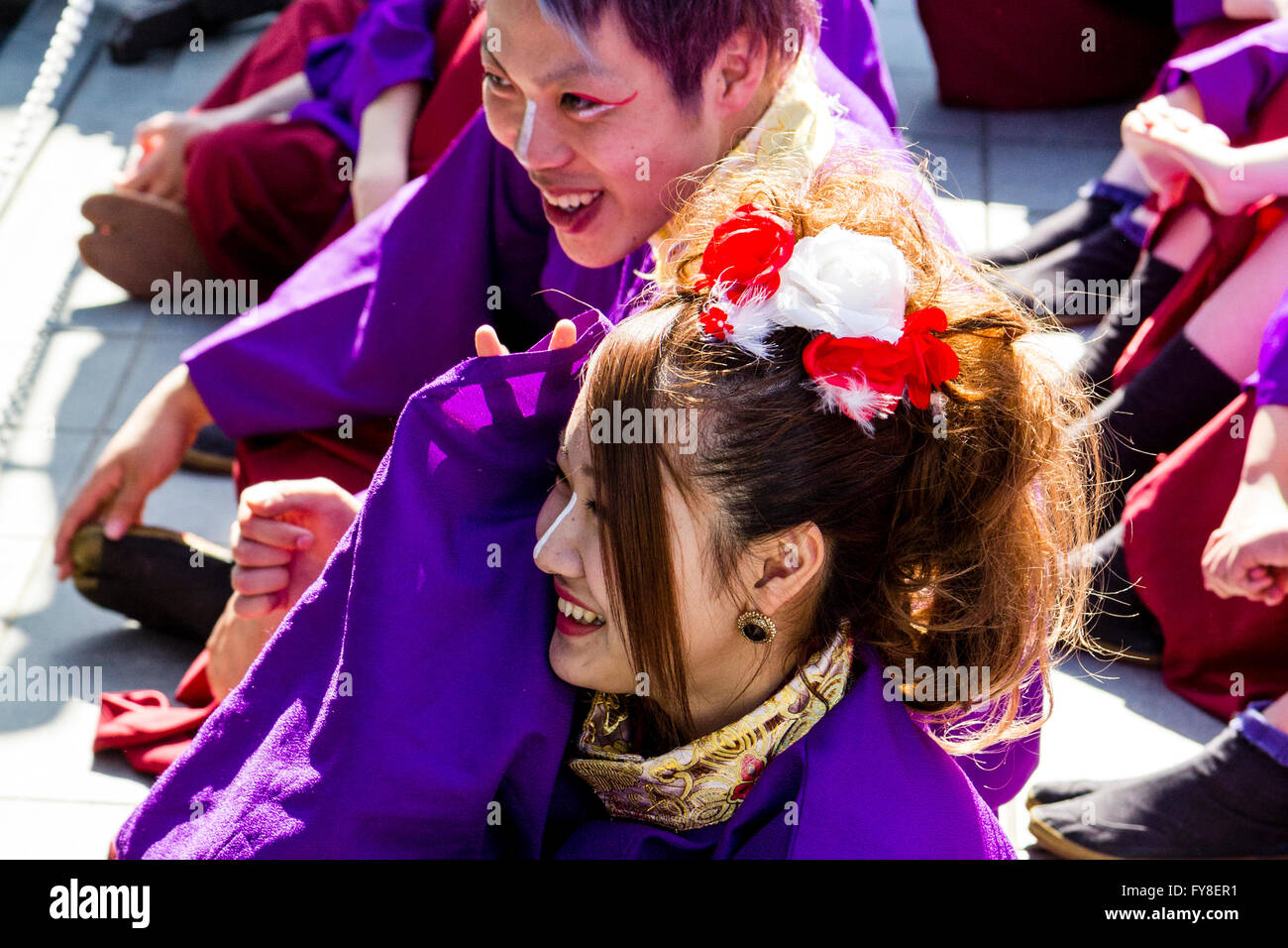 Auf der Suche nach junger Mann sitzt neben junge Frau einen Witz zusammen teilen. In purpur Yukata während Yosakoi Dance Festival gekleidet. Stockfoto